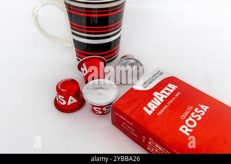 Lefkada, Grèce- 10.04.2024. Gros plan d'un paquet de café Lavazza Rossa, ses dosettes et une tasse, isolé sur fond blanc. Banque D'Images