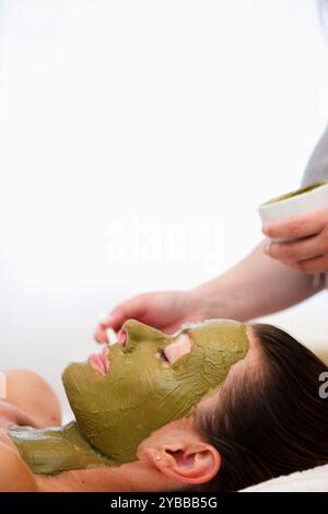 L'application de la main beauté masque vert sur le visage Banque D'Images