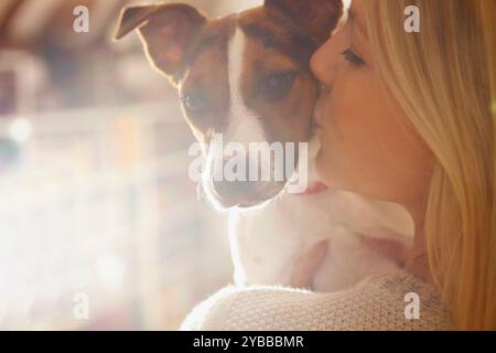 Young Woman Kissing Dog Banque D'Images