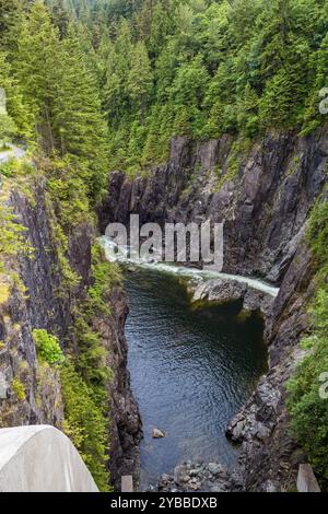 Un canyon spectaculaire au barrage de Cleveland dans le nord de Vancouver, avec des parois rocheuses abruptes et une rivière qui coule en contrebas, entouré d'une forêt verdoyante et luxuriante Banque D'Images