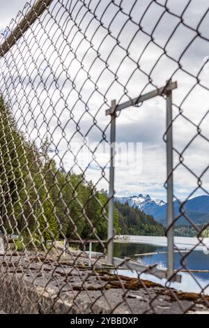 Une vue panoramique sur le réservoir du barrage de Cleveland encadré par une clôture à maillons, mettant en valeur les montagnes Twin Sisters Banque D'Images