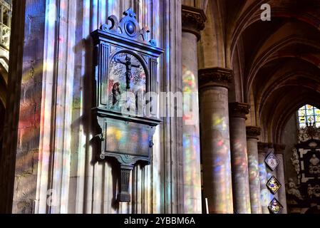 La lumière oblique du soleil a brillé à travers des vitraux sur des piliers dans l'église notre-Dame des victoires du XVe siècle au Sablon, Bruxelles, Belgique Banque D'Images