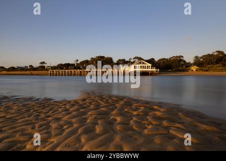 Lever de soleil se reflétant sur les ondulations de sable et l'eau calme à Barwon Heads Banque D'Images