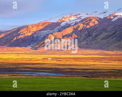 Vue sur les prairies jusqu'au glacier Eyjafjallajökull, vallée de Fljotsdalur, lumière chaude au coucher du soleil, Islande Banque D'Images