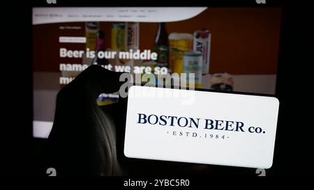 Personne tenant un smartphone avec le logo de la brasserie américaine Boston Beer Company sur l'écran en face du site Web. Concentrez-vous sur l'affichage du téléphone. Banque D'Images