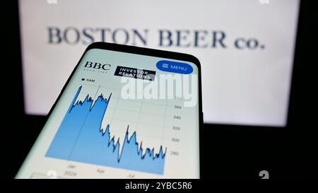 Téléphone portable avec le site Web de la brasserie américaine Boston Beer Company sur l'écran devant le logo de l'entreprise. Concentrez-vous sur le coin supérieur gauche de l'écran du téléphone. Banque D'Images