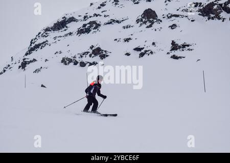 Jeune skieuse en action ski alpin dans une station de ski européenne. Vue latérale du skieur descendant en station d'hiver, les trois Vallées, France. Banque D'Images