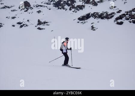 Jeune skieuse en action ski alpin dans une station de ski européenne. Vue latérale du skieur descendant en station d'hiver, les trois Vallées, France. Banque D'Images