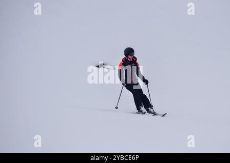 Jeune skieuse en action ski alpin dans une station de ski européenne. Vue latérale du skieur descendant en station d'hiver, les trois Vallées, France. Banque D'Images