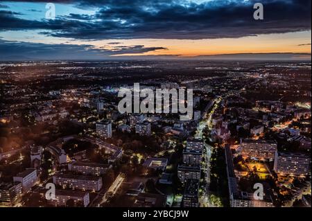 Une vue aérienne à couper le souffle d'un paysage urbain au crépuscule, mettant en valeur des rues et des bâtiments illuminés sous un ciel crépusculaire. L'image capture la vie urbaine et Banque D'Images