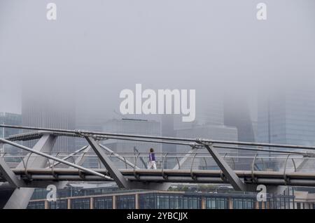 Londres, Royaume-Uni. 18 octobre 2024. Une personne marche le long du Millennium Bridge alors que le brouillard descend sur la City de Londres, le quartier financier de la capitale. Crédit : Vuk Valcic/Alamy Live News Banque D'Images