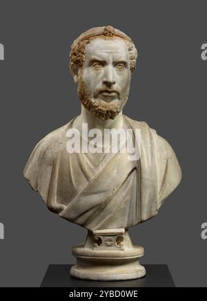 Portrait buste de l'homme, peut-être un prêtre de Serapis, A.D. 180-220. Informations complémentaires : ce buste portrait, probablement trouvé en Egypte, montre un homme portant un diadème décoré d'une étoile à sept branches. Des traces de peinture sont visibles : rougeâtre sur les cheveux et la barbe, bleu pâle sur les yeux. Le diadème était autrefois doré mais il reste peu de dorure. L'étoile à sept branches était un symbole de la divinité égyptienne Sérapis. Le Dieu Serapis a été créé avec des éléments tirés de la religion grecque et égyptienne. Au moment où les Romains ont pris le contrôle de l'Égypte en 31 av. J.-C., Serapis était devenu un Dieu important et populaire. Thi Banque D'Images