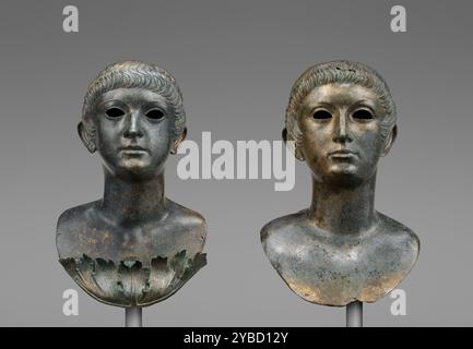 Paire de bustes Portrait de jeunes et une paire non apparentée d'yeux de marbre, A.D. 60-70. Informations supplémentaires : qui représentent ces deux bustes de portrait en bronze? Ils sont très semblables en apparence, bien que l'un semble légèrement plus vieux que l'autre. Les deux garçons ont une coiffure avec une vague distinctive sur le front, qui était populaire pendant le règne de l'empereur romain Néron. Les bustes avaient à l'origine de longues mèches de cheveux fabriquées séparément, qui étaient attachées à l'arrière des têtes. Leurs longues verrous peuvent indiquer qu'ils représentent une paire de préposés dans une organisation de jeunesse appelée Iuventus, wh Banque D'Images