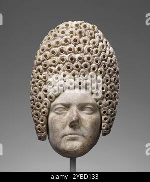 Portrait d'une dame flavienne, A.D. 70-90. Informations supplémentaires : la femme représentée adopte une expression sérieuse. Ses lèvres sont minces et légèrement tournées vers le bas ; les yeux sont étroits. Le visage a un aspect légèrement lourd en raison de l'aspect arrondi des joues et du menton et de la peau supplémentaire pendante sous la mâchoire. Elle porte la coiffure élaborée de la période Flavienne avec une tour de cheveux immensément haute qui s'étend également sur le côté de son visage devant les oreilles. Les pincurls serrés sont rendus avec des trous de perçage de tailles variables et des incisions en spirale. Derrière la tour de cheveux, les mèches sont Banque D'Images