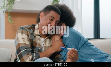 Couple afro-américain mari et femme heureuse petite amie et petit ami excité avec le réapprovisionnement positif du test de grossesse dans le bonheur de la famille Banque D'Images