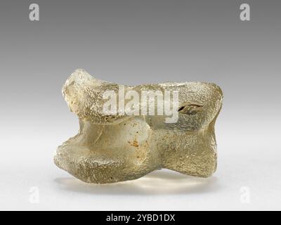 Astragalos, 1st Century B.C. - 1st Century A.D. informations supplémentaires : un des jouets les plus populaires parmi les enfants grecs dans l'antiquité était l'astragalos, ou Knucklebone. Typiquement, l'os de la cheville de la patte arrière d'une chèvre ou d'un mouton était utilisé. Mais cette pièce est faite de verre, moulée pour ressembler à un véritable squelette d'un animal. Les enfants ont roulé de l'astragaloi comme des dés. Chaque côté a reçu une valeur numérique unique. Comme les dés modernes, les valeurs sur les côtés opposés du jouet totalisent sept. Dans d'autres jeux, les joueurs tentent de frapper les articulations d'un adversaire hors du centre d'un cercle, ou de les jeter Banque D'Images