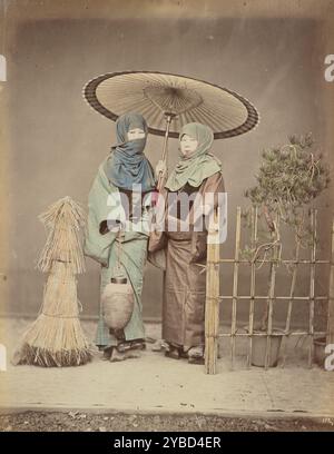 Filles portant Lanterne en papier dans la soirée d'hiver, années 1870-1890s. Deux femmes debout dehors, l'une tenant un parapluie en papier et l'autre tenant une lanterne en papier. Banque D'Images