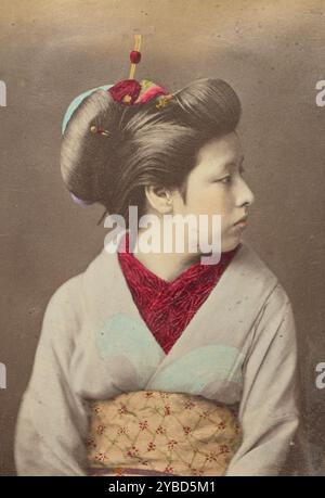 Femme japonaise de profil, 1868-1880. Portrait en studio d'une femme assise, la tête tournée complètement vers le côté droit de l'image. Elle porte un kimono japonais traditionnel et ses cheveux tirés vers le haut et fixés avec des peignes décoratifs et des épingles. Banque D'Images