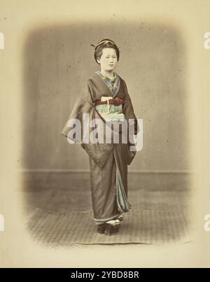 Femme en robe traditionnelle, vers 1868. Portrait en pied d'une femme portant un kimono et des sandales (gata). Banque D'Images