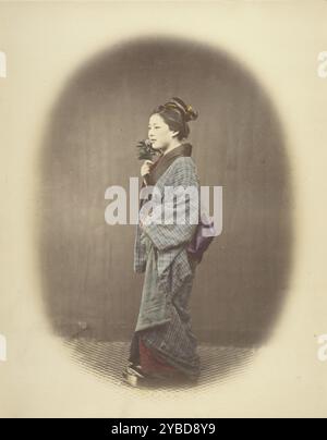 Une jeune dame venant du bain, 1863-1868. Portrait en pied d'une femme vêtue d'un kimono, debout en 3/4 profil. Elle tient une fleur sur son visage avec sa main droite. Banque D'Images