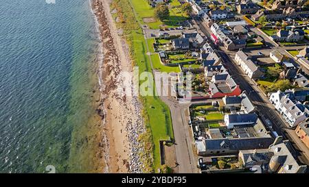 Golspie Sutherland Écosse la route A9 et la mer à marée haute maisons de ville près de la plage de sable fin en automne Banque D'Images