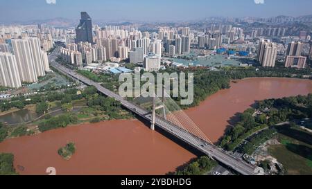 (241018) -- LANZHOU, Oct. 18, 2024 (Xinhua) -- une photo de drone aérien prise le 26 septembre 2024 montre le pont Yintan au-dessus du fleuve jaune à Lanzhou, dans la province du Gansu au nord-ouest de la Chine. Lanzhou, autrefois centre de transport, forteresse militaire et importante zone commerciale le long de l'ancienne route de la soie, est la seule capitale provinciale où coule le fleuve jaune. La section Lanzhou du ruisseau principal du fleuve jaune est de 150,7 kilomètres de long, dont 47,5 kilomètres traversent la zone urbaine. Le fleuve jaune est également une source importante d'eau potable à Lanzhou. Grâce au continuo Banque D'Images