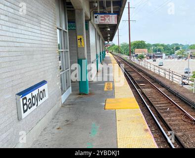 Babylon, New York, États-Unis - 8 juillet 2024 : vue vers l'ouest sur la plate-forme surélevée de la gare de Babylon Roailroad sans trains sur les voies. Banque D'Images