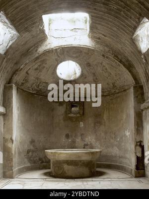 Forum Thermes, Pompéi, Italie, 2002. Bains publics, construits immédiatement après la fondation de la colonie (après 80 av. J.-C.). Elles étaient subdivisées en sections hommes et femmes. Chambre du "calidarium" avec son bain d'eau chaude. Bassin rempli d'eau froide pour que les baigneurs puissent se rafraîchir. La ville romaine de Pompéi (actuelle Campanie) a été enterrée sous la cendre volcanique et la pierre ponce lors de l'éruption du Vésuve en 79 après JC. Banque D'Images