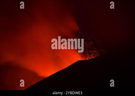 Etna in eruzione con spattering di lava dal cratere visto di notte Banque D'Images