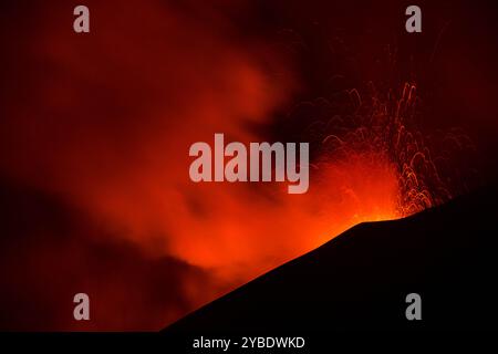 Etna in eruzione con spattering di lava dal cratere visto di notte Banque D'Images