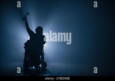 Femme handicapée recevant une coupe de victoire alors qu'elle était assise dans un fauteuil roulant dans une pièce sombre avec un rétroéclairage blanc. Banque D'Images