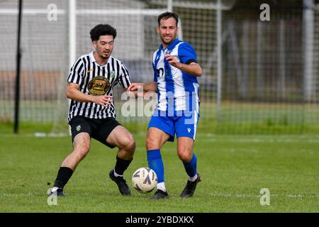 Pontardawe, pays de Galles. 5 octobre 2024. Scott Tomlinson de Giants grave se bat pour possession avec Alex Aldrich de Pontardawe Town lors du match du FAW amateur Trophy Round Two entre Pontardawe Town et Giants grave au Parc Ynysderw à Pontardawe, pays de Galles, Royaume-Uni le 5 octobre 2024. Crédit : Duncan Thomas/Majestic Media. Banque D'Images