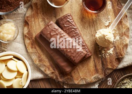 Barres de chocolat protéinées saines avec des ingrédients - poudre de protéines de lactosérum, miel, beurre d'arachide et de cacao, cacao brut et sirop d'érable Banque D'Images