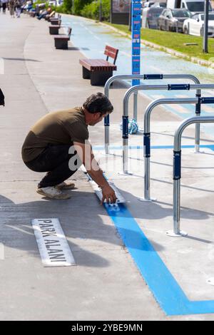 Istanbul, Turkiye - 14 octobre 2024 : les travailleurs de la municipalité métropolitaine d'Istanbul marquent des étiquettes sur les aires de stationnement pour vélos nouvellement construites le long du Bos Banque D'Images