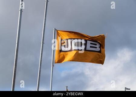 Newport, Shropshire, Royaume-Uni – 17 octobre 2024 : drapeau flottant avec le logo de la société de fabricant de machines de construction, JCB Banque D'Images