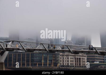 Londres, Royaume-Uni. 18 octobre 2024. Les gens marchent le long du Millennium Bridge tandis que le brouillard descend sur la City de Londres, le quartier financier de la capitale. Crédit : Vuk Valcic/Alamy Live News Banque D'Images