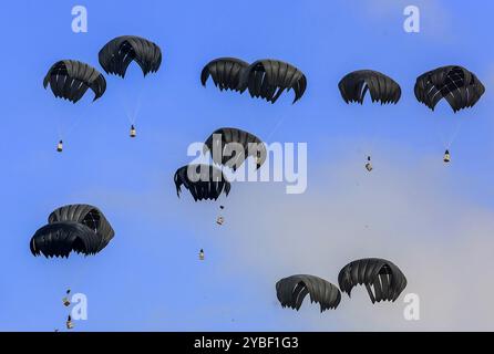 Khan Younis, Gaza. 17 octobre 2024. Des colis d’aide humanitaire largués d’avions sont vus atterrir en parachute dans la région d’Al-Mawasi alors que les attaques israéliennes se poursuivent à Khan Yunis, Gaza, le 18 octobre 2024. Le Hamas a confirmé la mort du dirigeant Yahya Sinwar vendredi dans une déclaration vidéo du haut responsable du Hamas Khalil. Photo de Anas Deeb/UPI crédit : UPI/Alamy Live News Banque D'Images