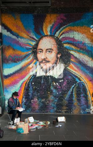 Un artiste de rue devant la murale de William Shakespeare de l'artiste James Cochran dans Clink Street. Londres. Banque D'Images