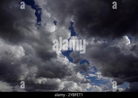 Rassemblement de nuages de tempête se dessinent au-dessus de la tête, remplis de différentes nuances de gris et de blanc, révélant des taches de ciel bleu pendant les heures de l'après-midi, suggesti Banque D'Images