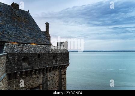 Vue sur les remparts du Mont Saint Michel avec la marée arrivant au coucher du soleil. Normandie, France, Europe Banque D'Images