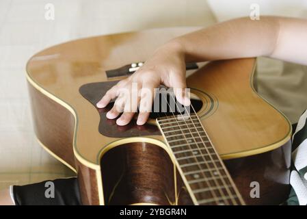 La main féminine à jouer sur la guitare acoustique. Close-up Banque D'Images