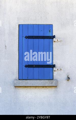 Vieille fenêtre avec volet peint en bois bleu sur mur peint en blanc Banque D'Images