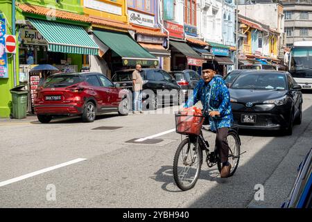 Homme à vélo dans la rue arabe Singapour Banque D'Images