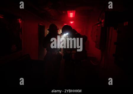 Des marins combattent un incendie simulé lors d'un exercice général à bord du porte-avions USS Nimitz (CVN 68) dans l'océan Pacifique, 17 octobre 2024. Ni Banque D'Images
