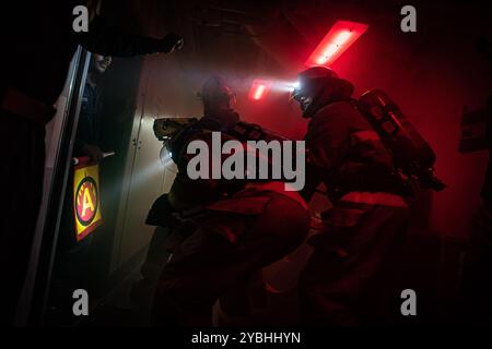 Des marins combattent un incendie simulé lors d'un exercice général à bord du porte-avions USS Nimitz (CVN 68) dans l'océan Pacifique, 17 octobre 2024. Ni Banque D'Images