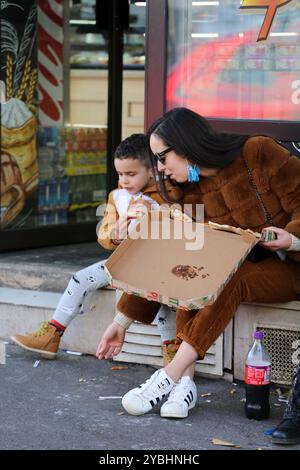 Marseille, France. 22 décembre 2020. Les membres de la même famille mangent des pizzas devant une boulangerie et une pâtisserie dans la ville française de Marseille. La France a levé le confinement le 15 décembre, mais les bars, restaurants et cafés doivent rester ouverts uniquement aux emprises jusqu’au 20 janvier au moins Banque D'Images