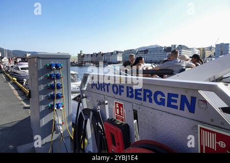 7 septembre, 2024 Bergen, Norvège la famille profite d'un verre le soir sur son bateau de croisière qui recharge ses batteries sur le port du Bryggen Hansa Banque D'Images