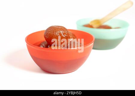 Deux bols colorés remplis de gulab jamun dessert sur fond blanc. Banque D'Images