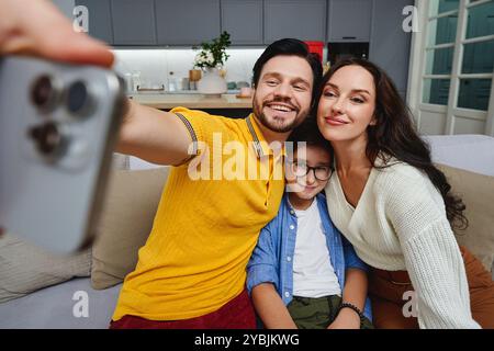 Temps de liaison familiale capturé dans un salon confortable tout en prenant des selfies Banque D'Images