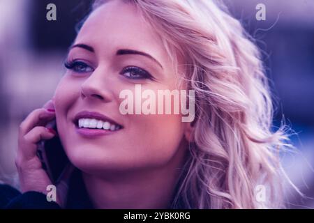 Jeune femme explore joyeusement la ville en vacances, souriant et discutant sur son téléphone, à l'air insouciant et moderne Banque D'Images